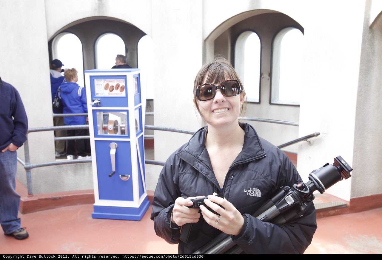 Photographer Smiling at Pressed Penny Souvenir Machine