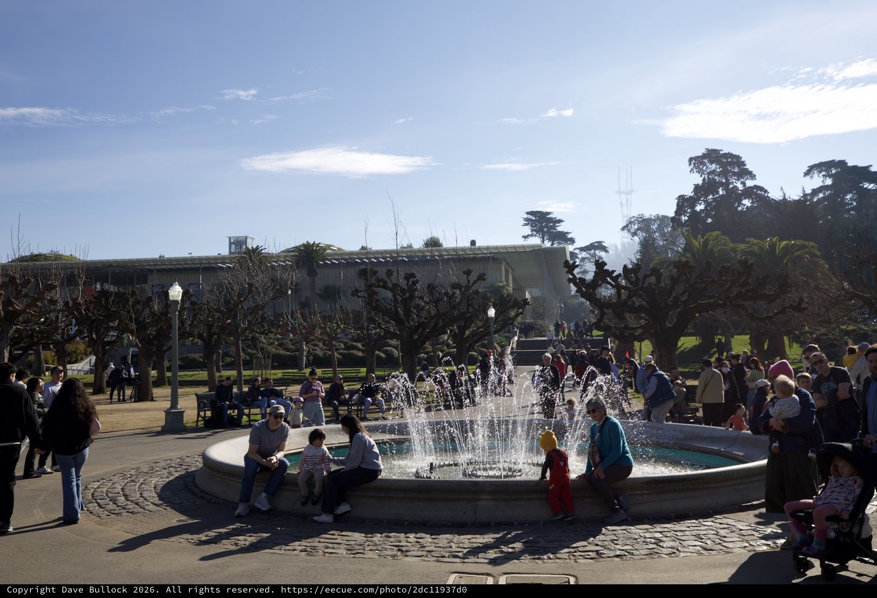 Families Gathering Around Fountain on Sunny Day