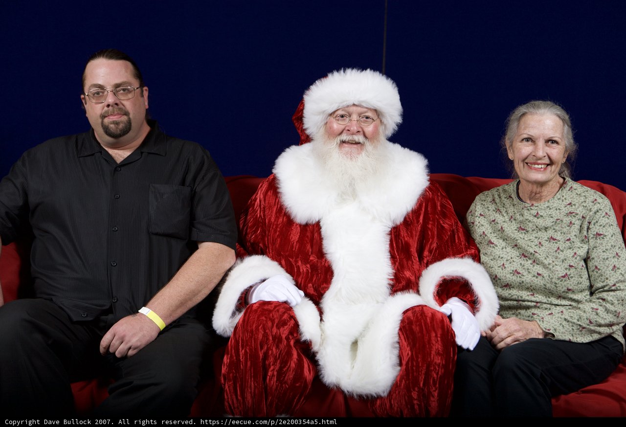 Santa Claus Joins Party Guests on Red Couch