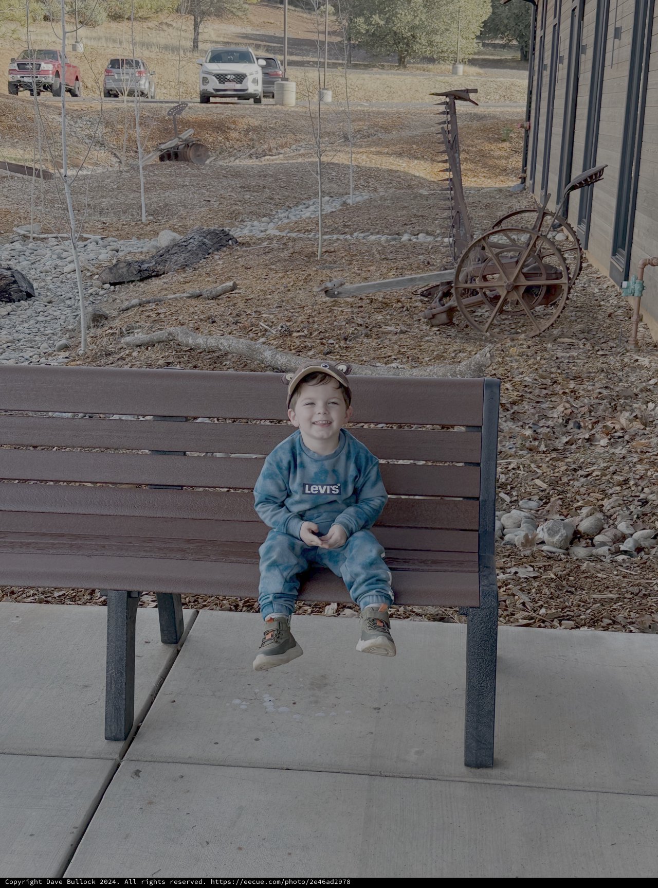 Young Child Sitting on Park Bench Outdoors