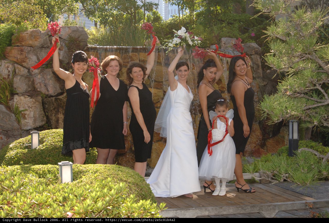 Bridal Party Celebrates with Bouquets at Garden Waterfall