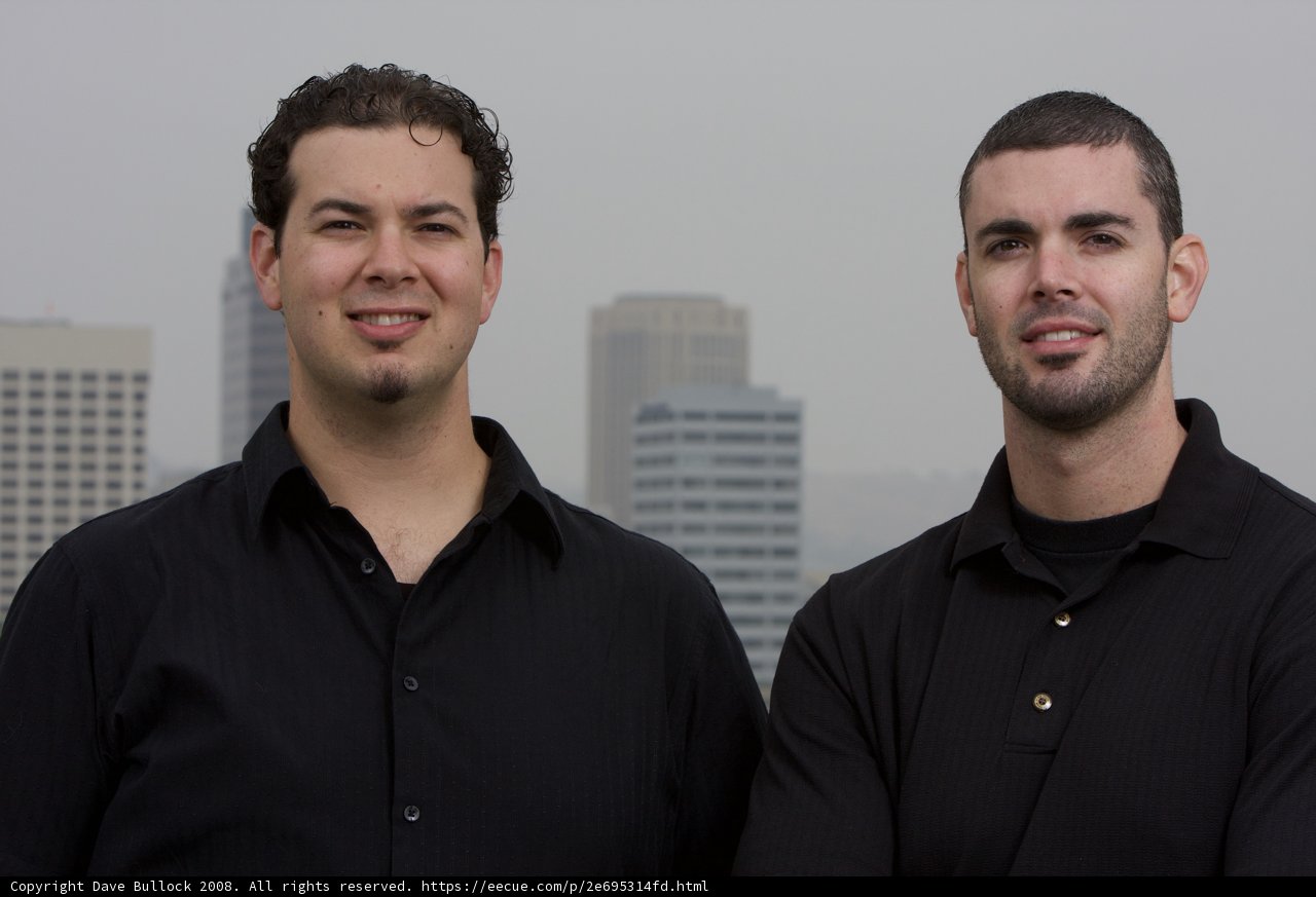 Two Happy Men in Black Shirts at a City Skyscraper