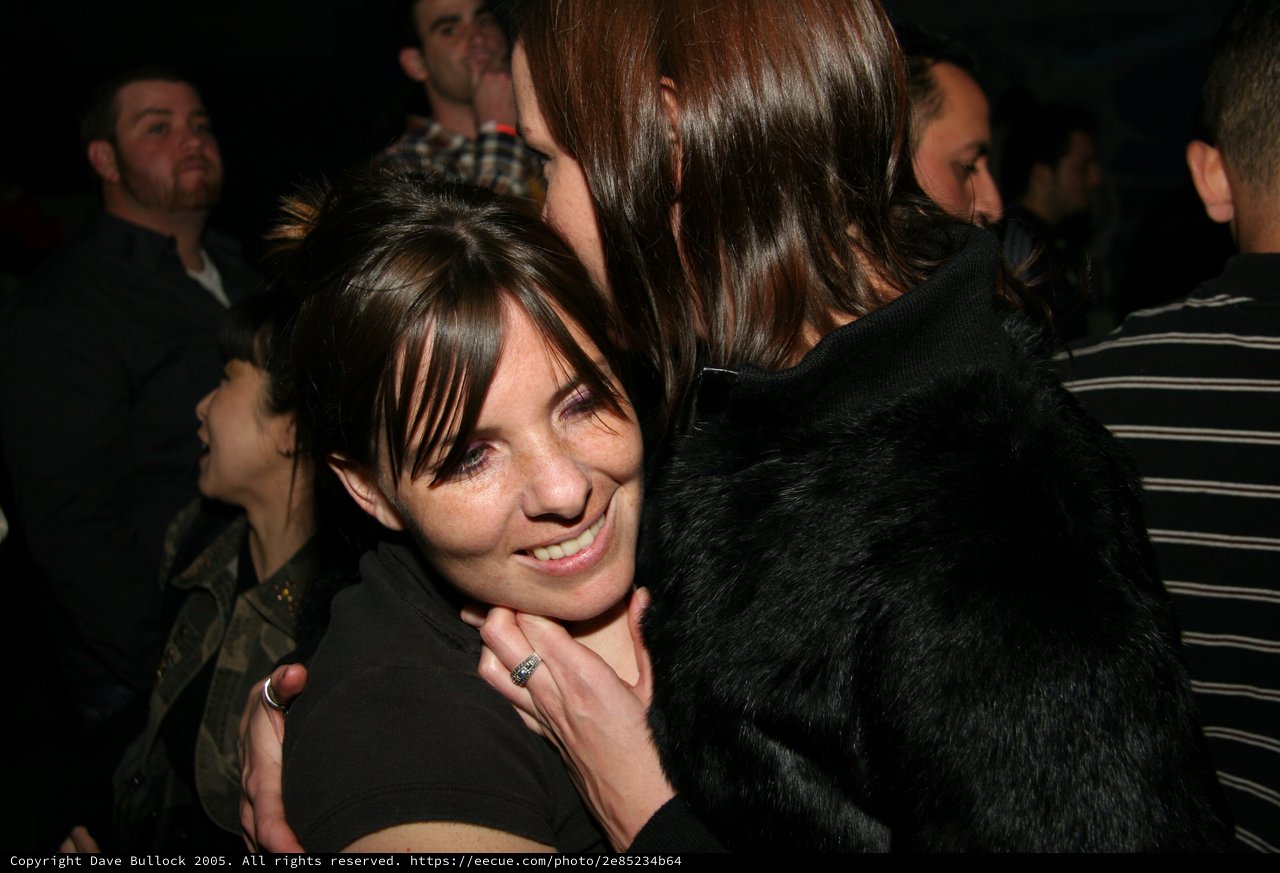 Warm Embrace at a Crowded Nighttime Gathering