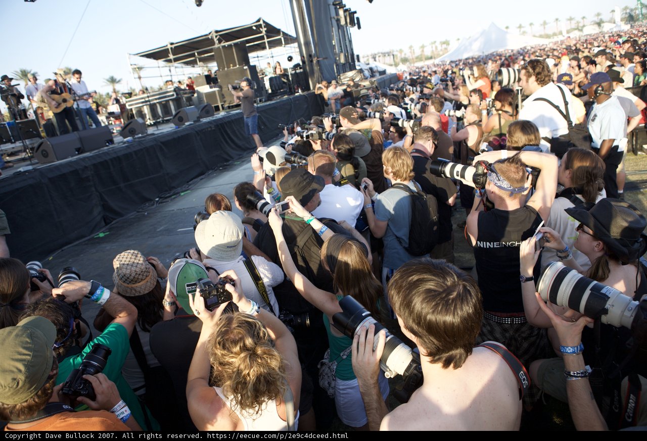 Paparazzi at Coachella Caption: A massive crowd of people capture every moment of the concert with their cameras and hats.