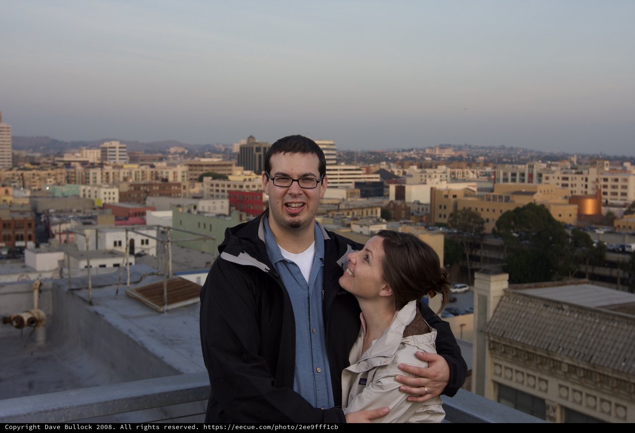 Couple Embracing on Urban Rooftop at Dusk