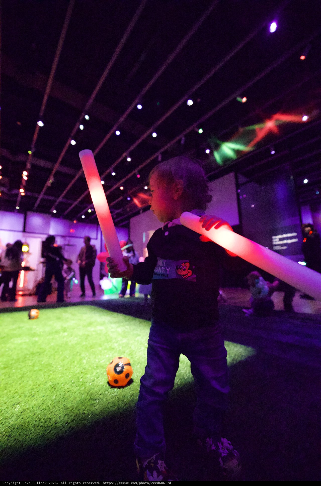 Child Playing with Light Sabers at Baby Rave Event