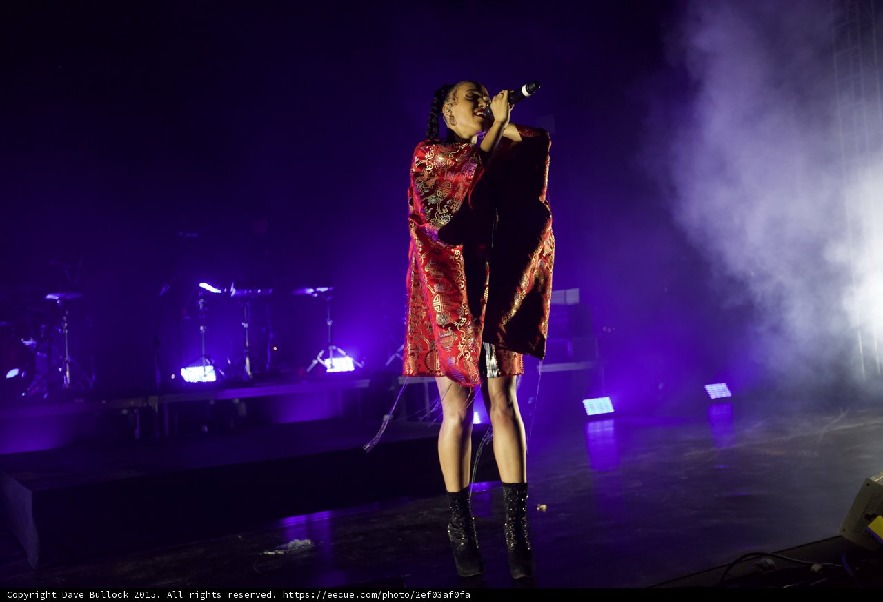 FKA twigs Full Body Singing Microphone Raised Looking Up Kimono Red Brocade Gold Patterns Black Bodysuit Boots Purple Lighting White Haze LED Panels Band Stage Monitor