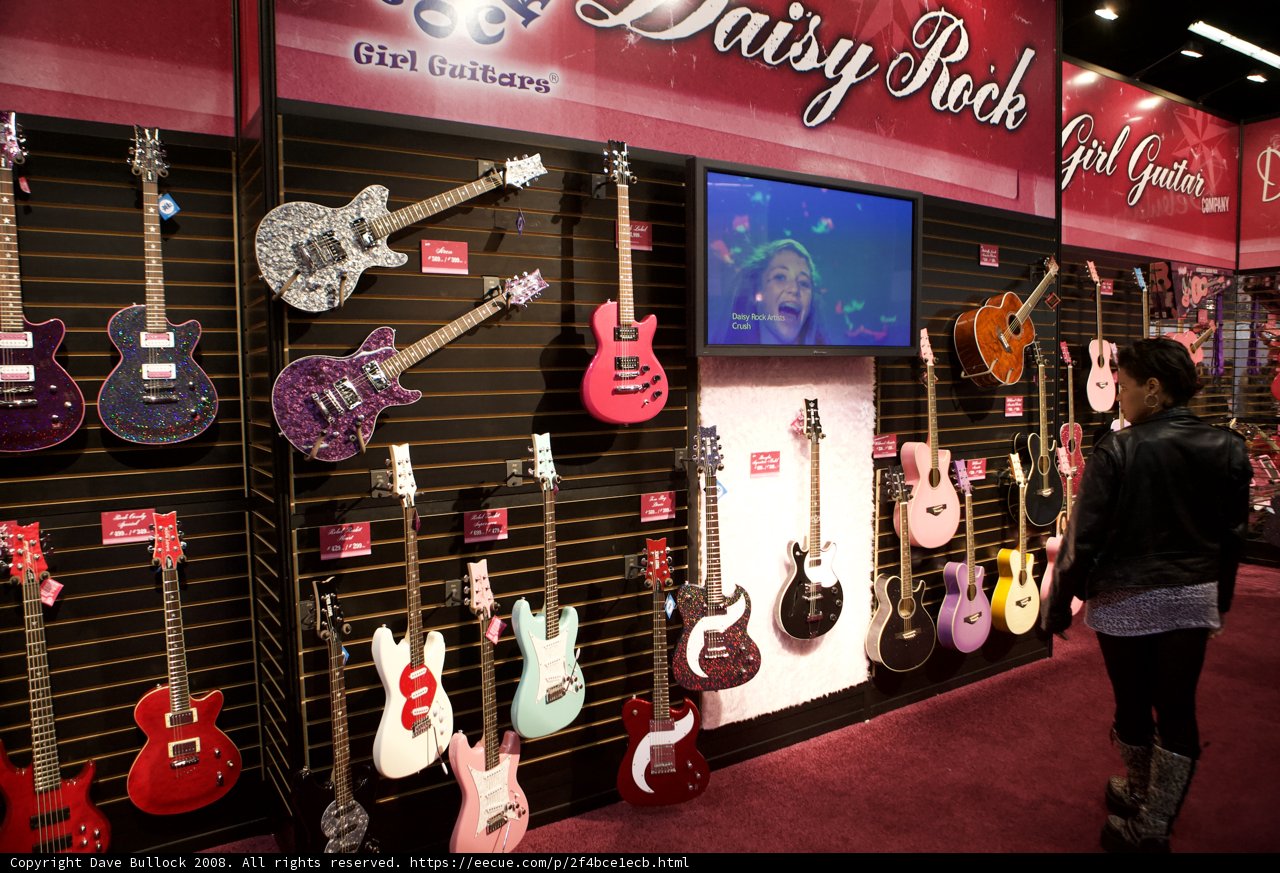 A Woman Admires the 22 Electric Guitars on Display