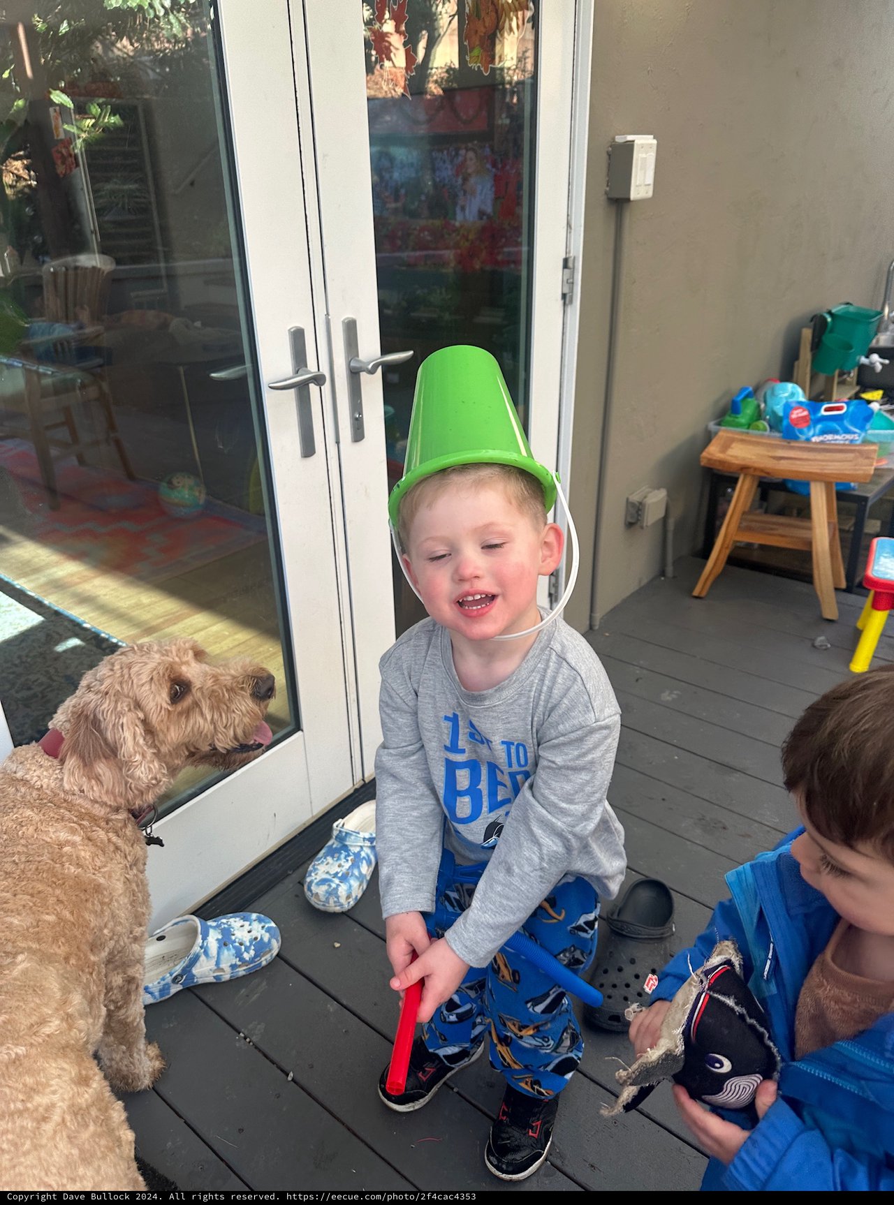 Children Playing with Funnel Hat on Patio