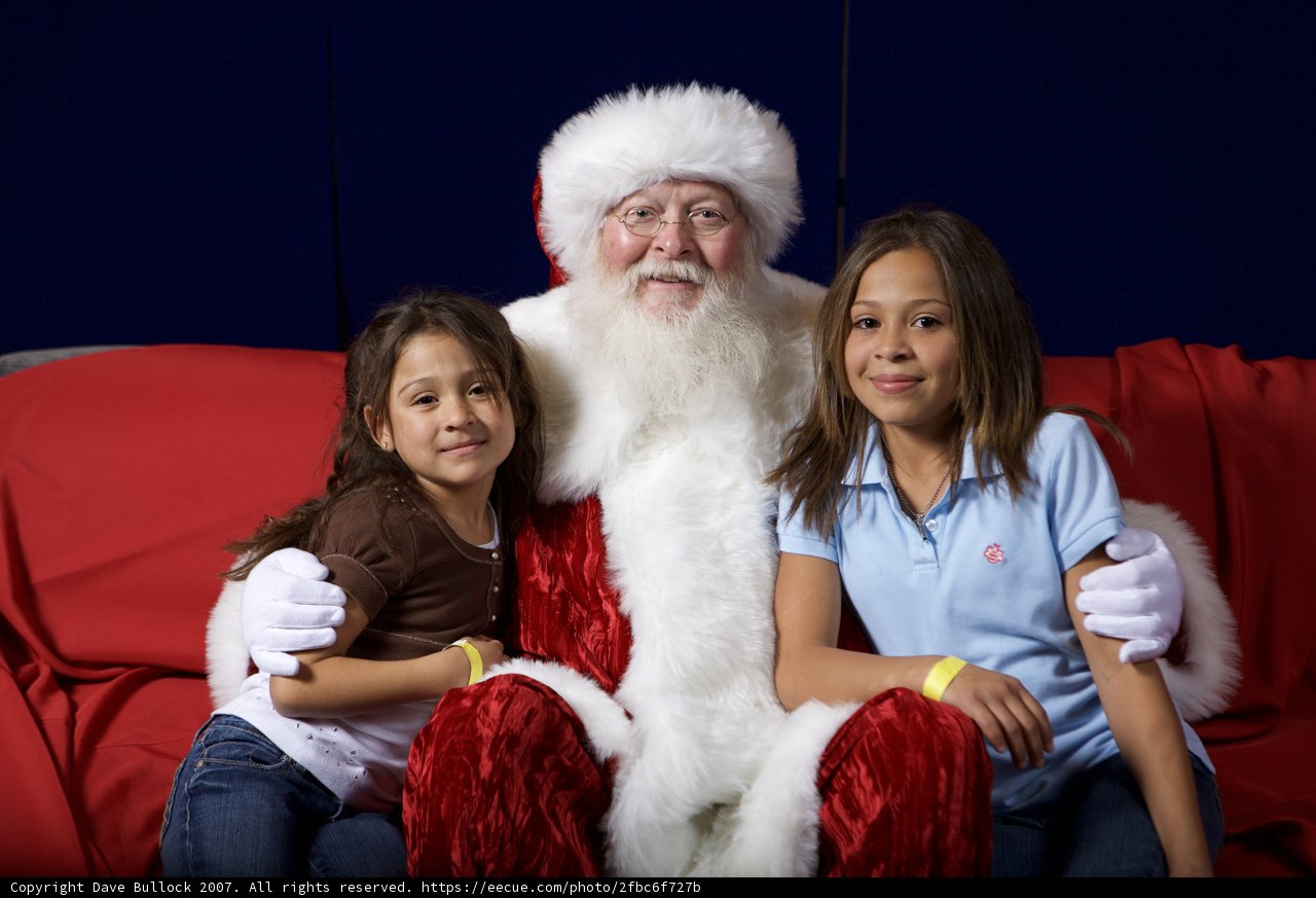Santa Claus and Two Girls Sitting on a Couch