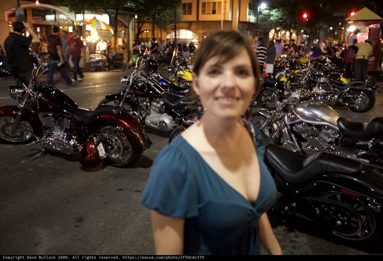 Woman Smiling Amid Motorcycle Rally at Night