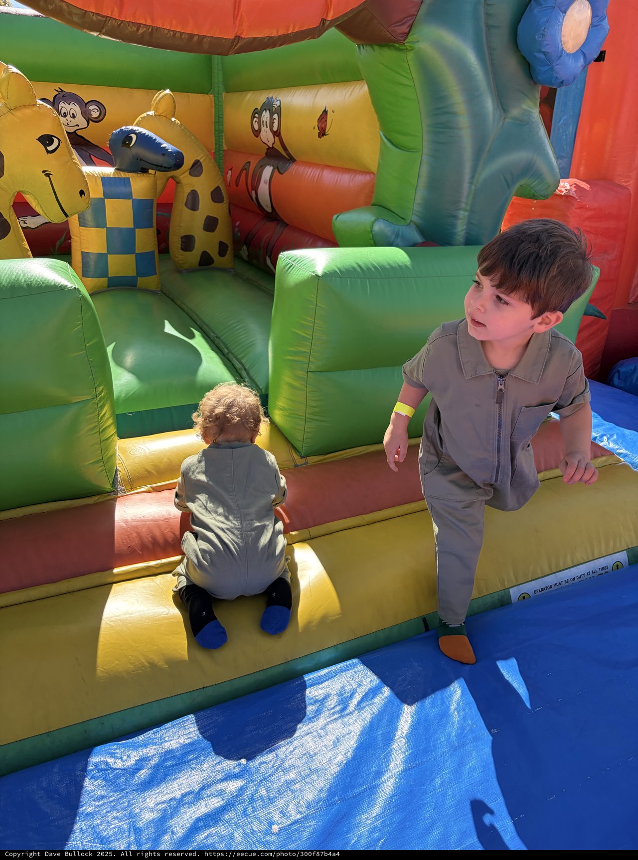 Two Boys Playing on Colorful Inflatable Bounce House