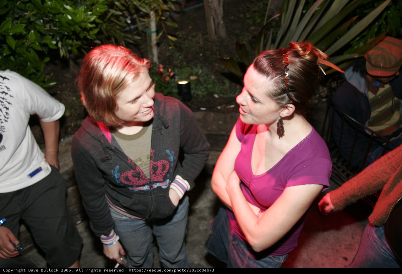 Two Women Conversing at an Outdoor Night Gathering