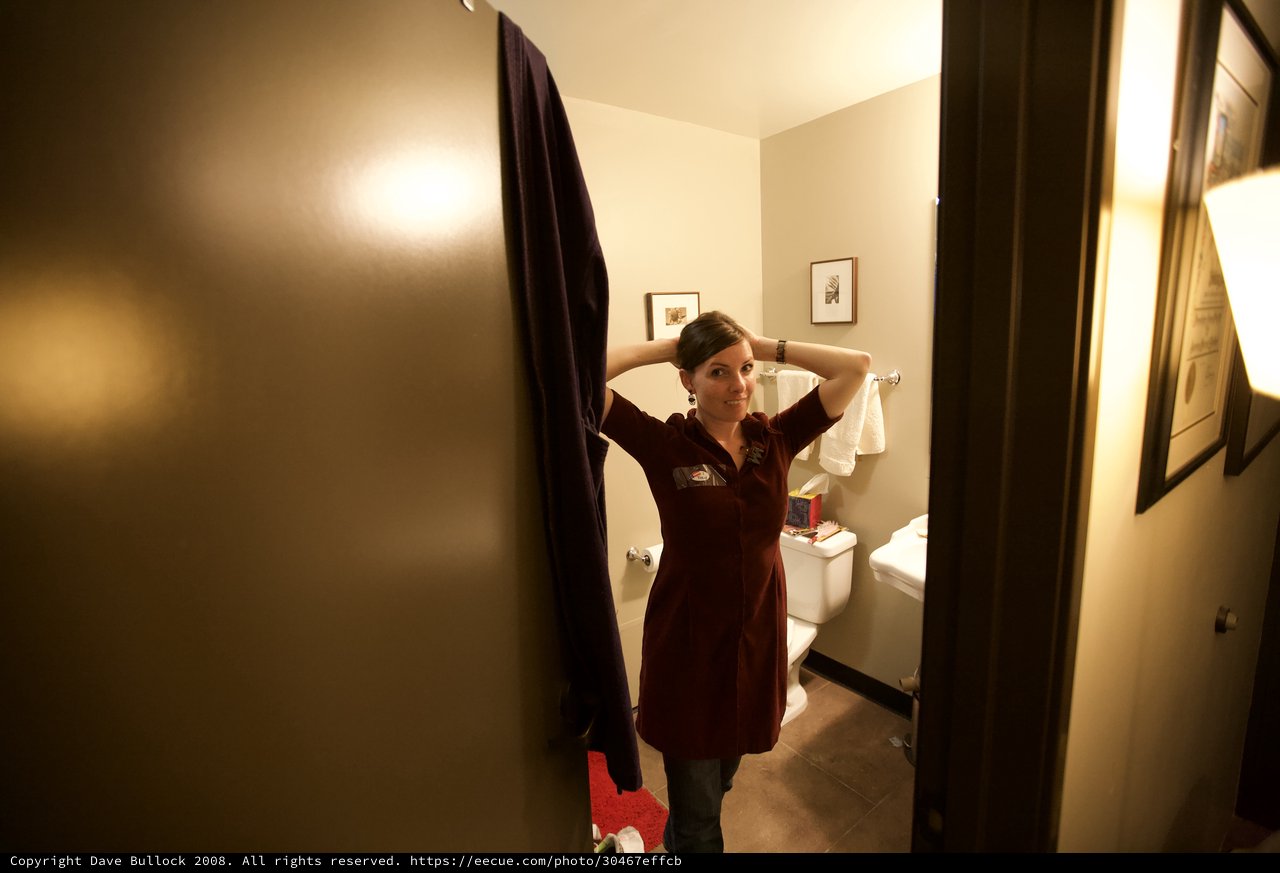 Woman Fixing Hair in Bathroom Doorway Portrait