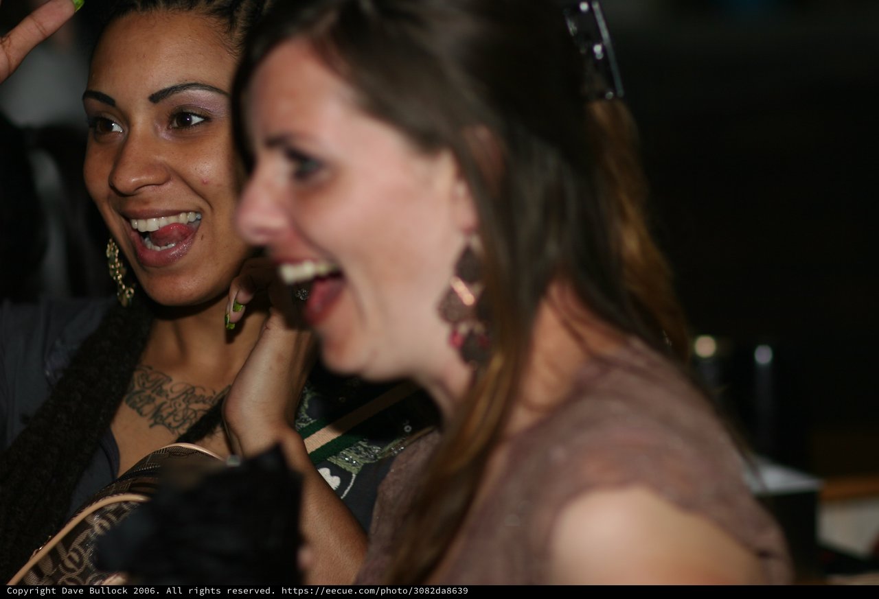 Two Women Laughing Together at Nighttime Event
