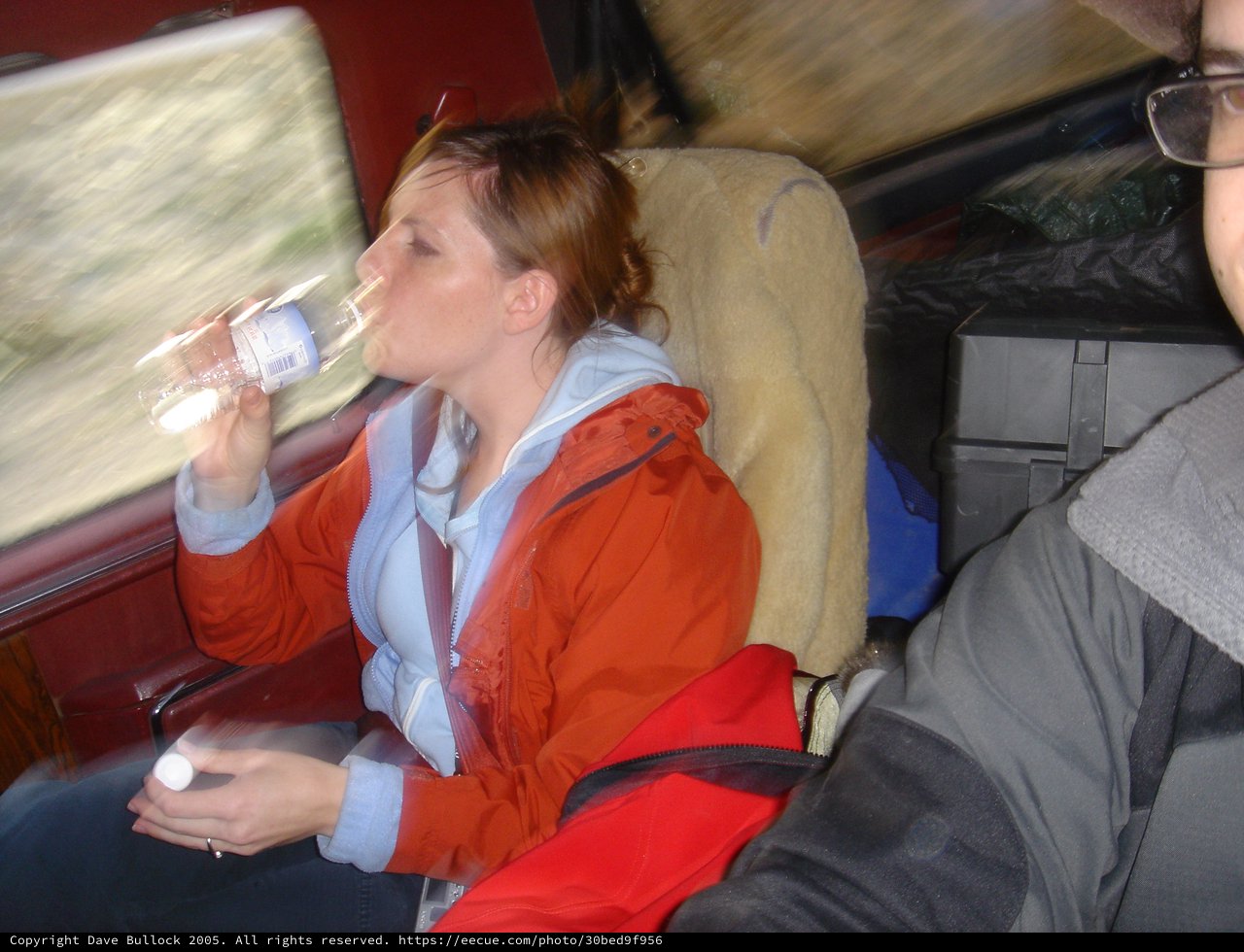 Woman Drinking Water on a Moving Train