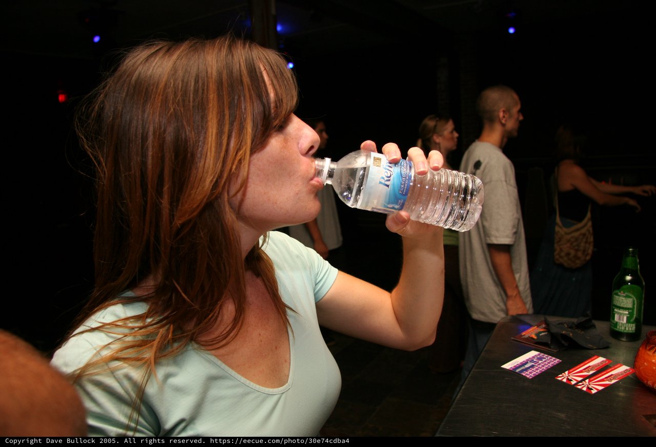 Young Woman Hydrating at a Nightclub Event