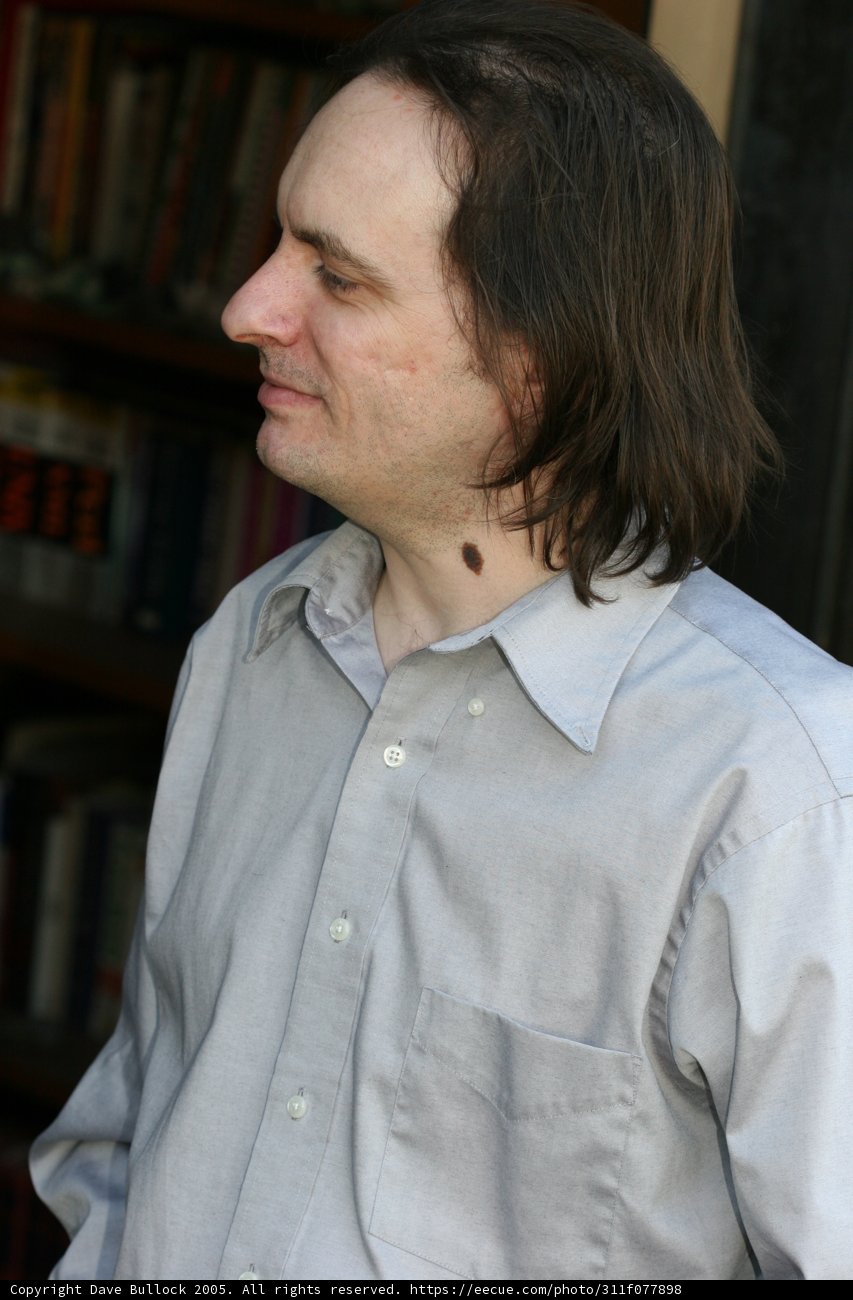 Man with Long Hair Surrounded by Books