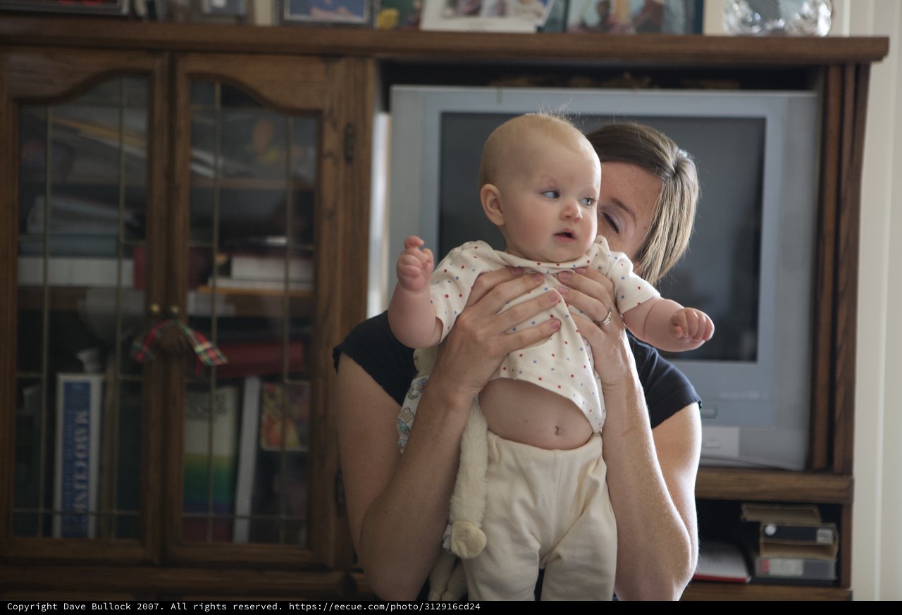 Mother Holds Curious Baby in Living Room