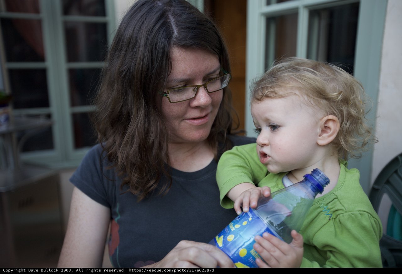 Mother and Toddler Share a Water Bottle Moment
