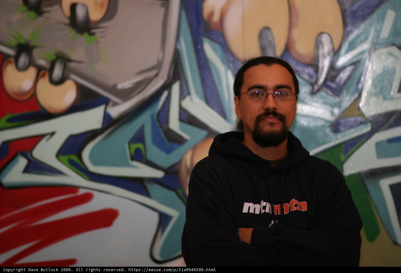 Bearded Man Poses in Front of Graffiti Wall