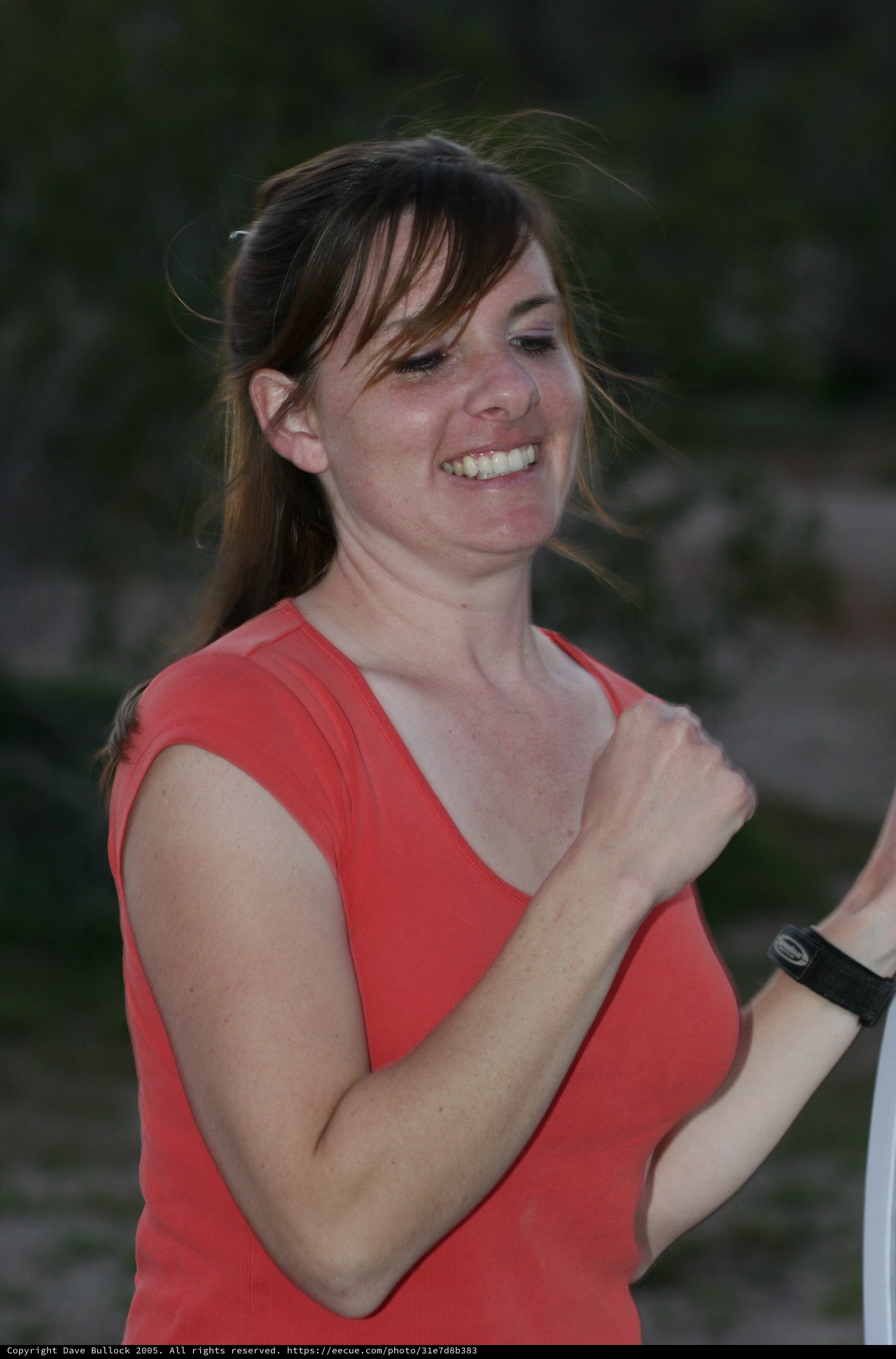 Joyful Woman in Red Laughing Outdoors at Dusk