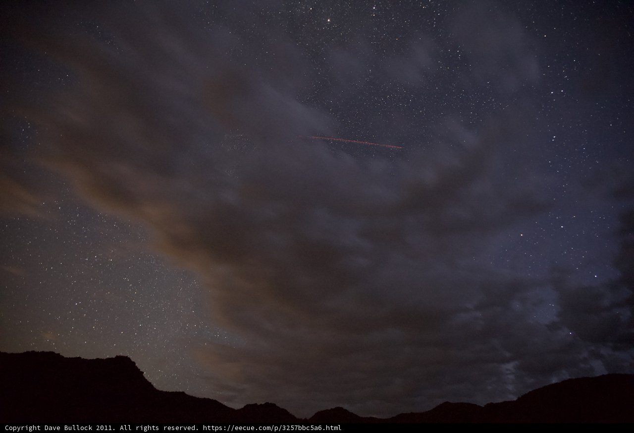 Jet soaring through the night sky above majestic mountains