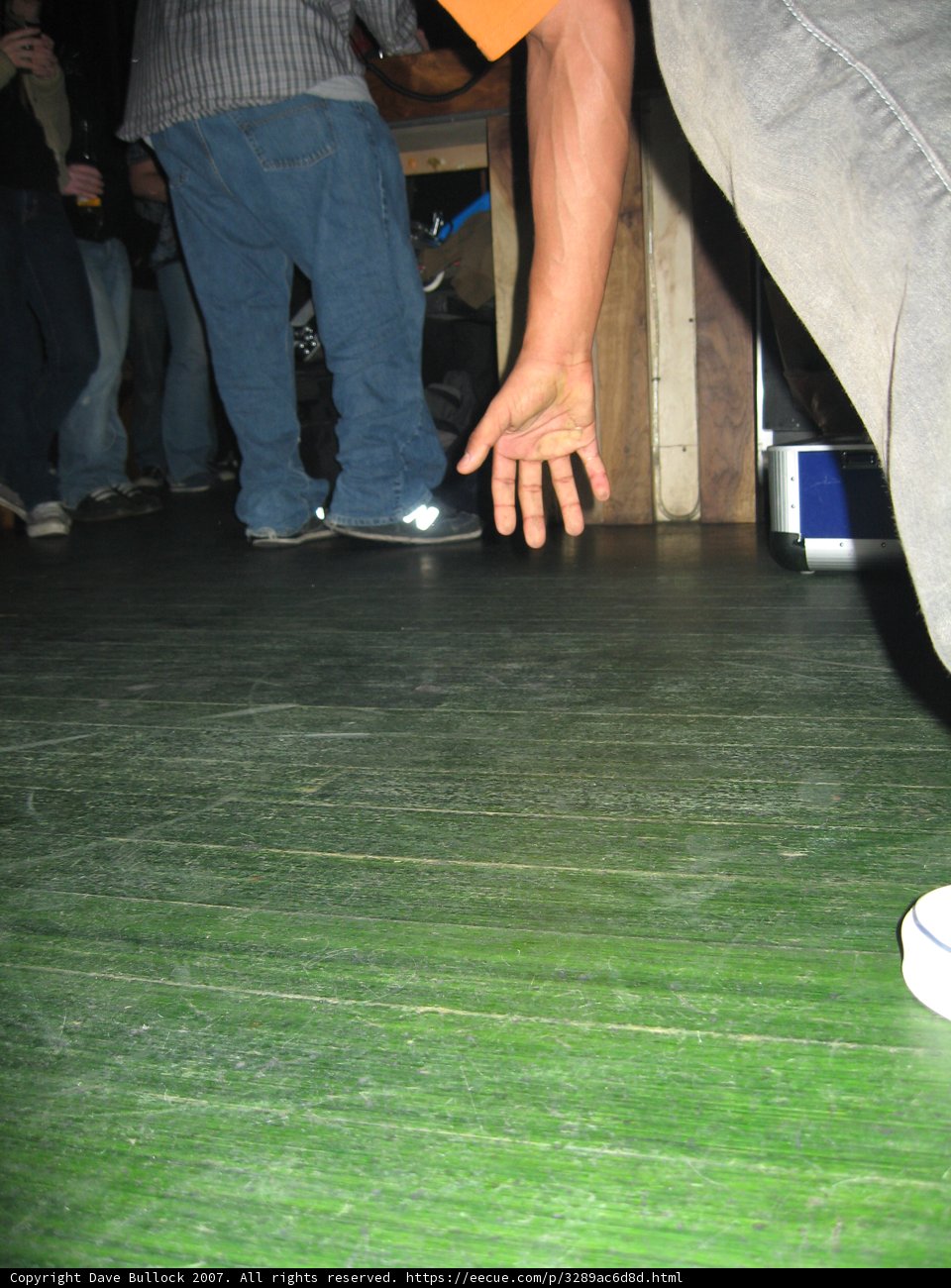 Grey Shirted Man on Plywood Floor