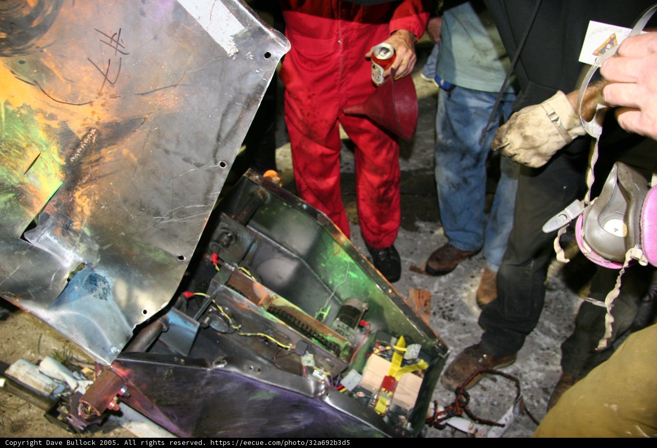 Group of Workers Inspecting Metal Object in Factory