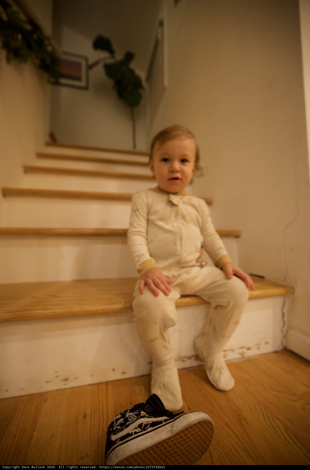 Toddler in White Pajamas Sitting on Wooden Stairs