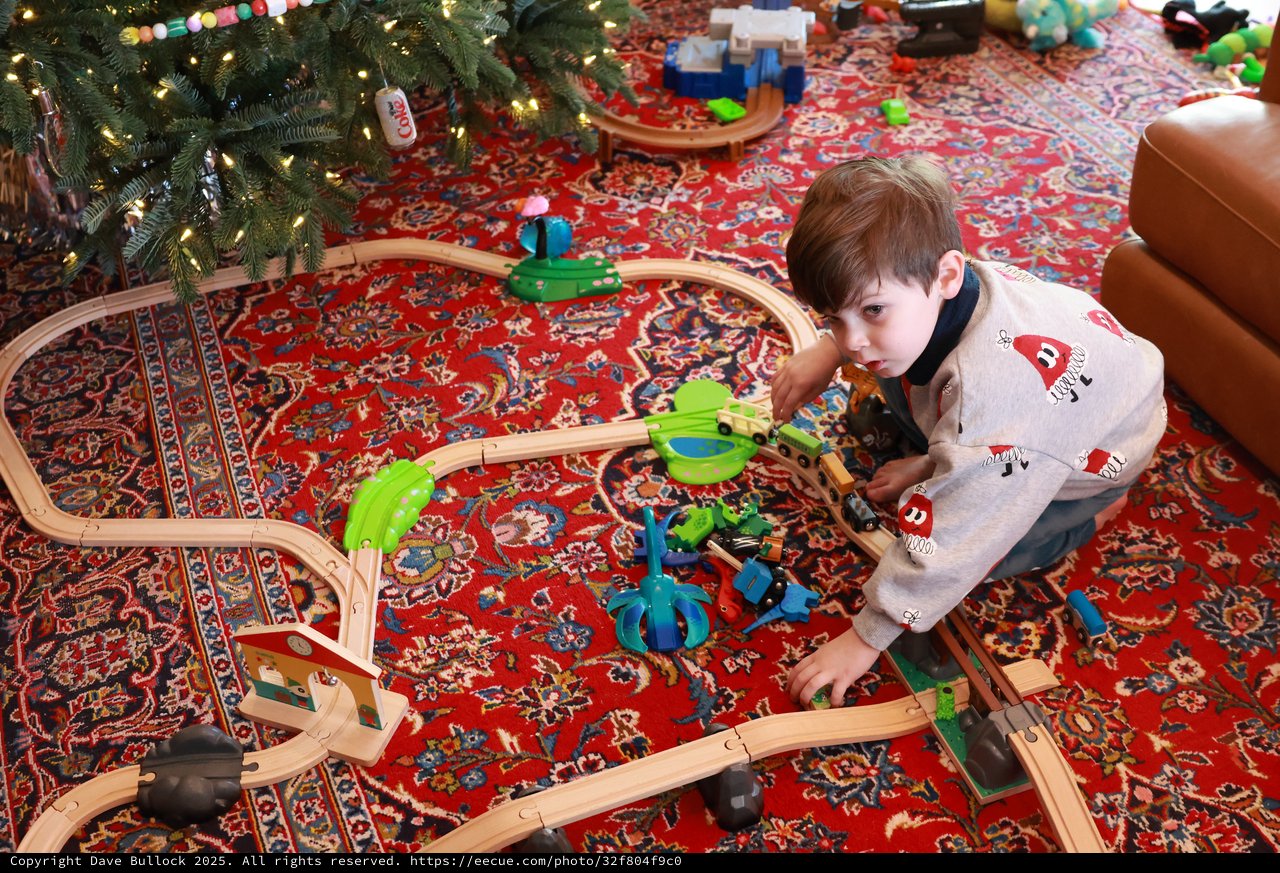 Boy Playing with Wooden Train Set on Christmas Morning