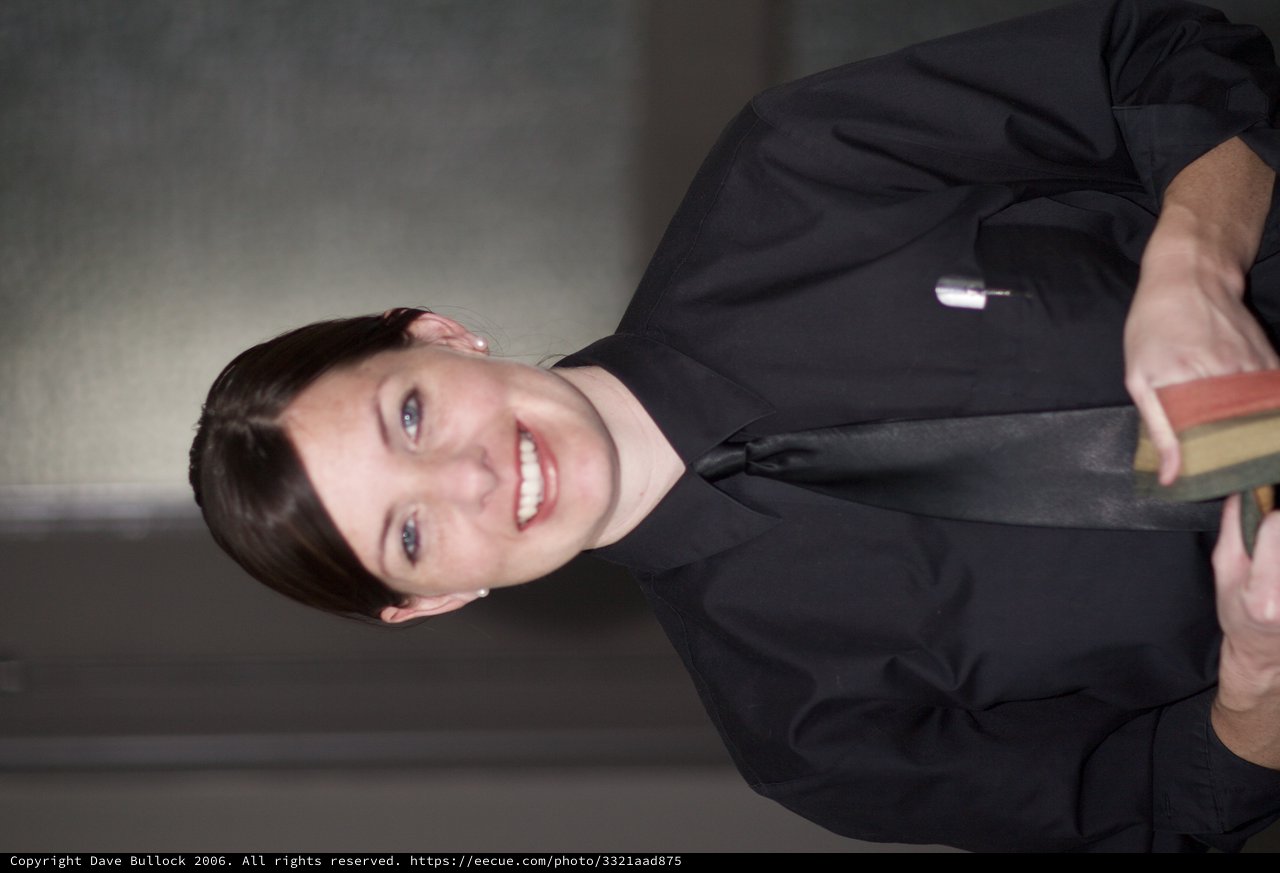 Smiling Woman in Black Uniform Holding Books