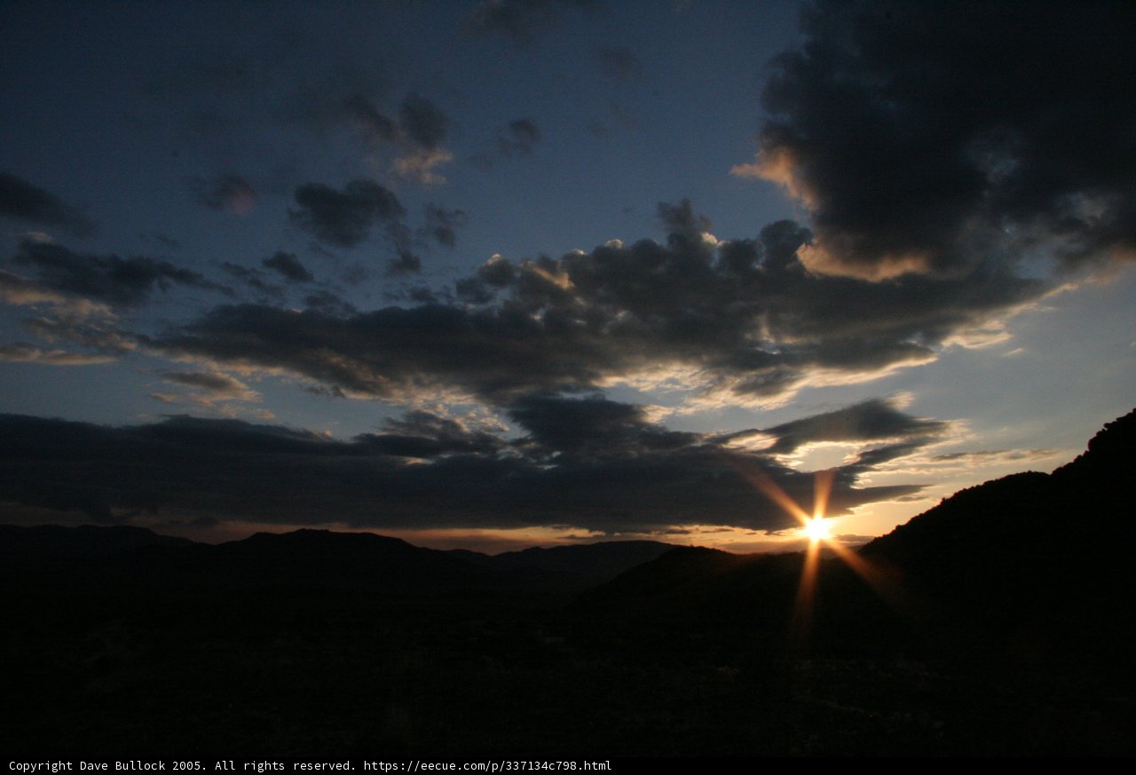 Sun setting behind dark clouds