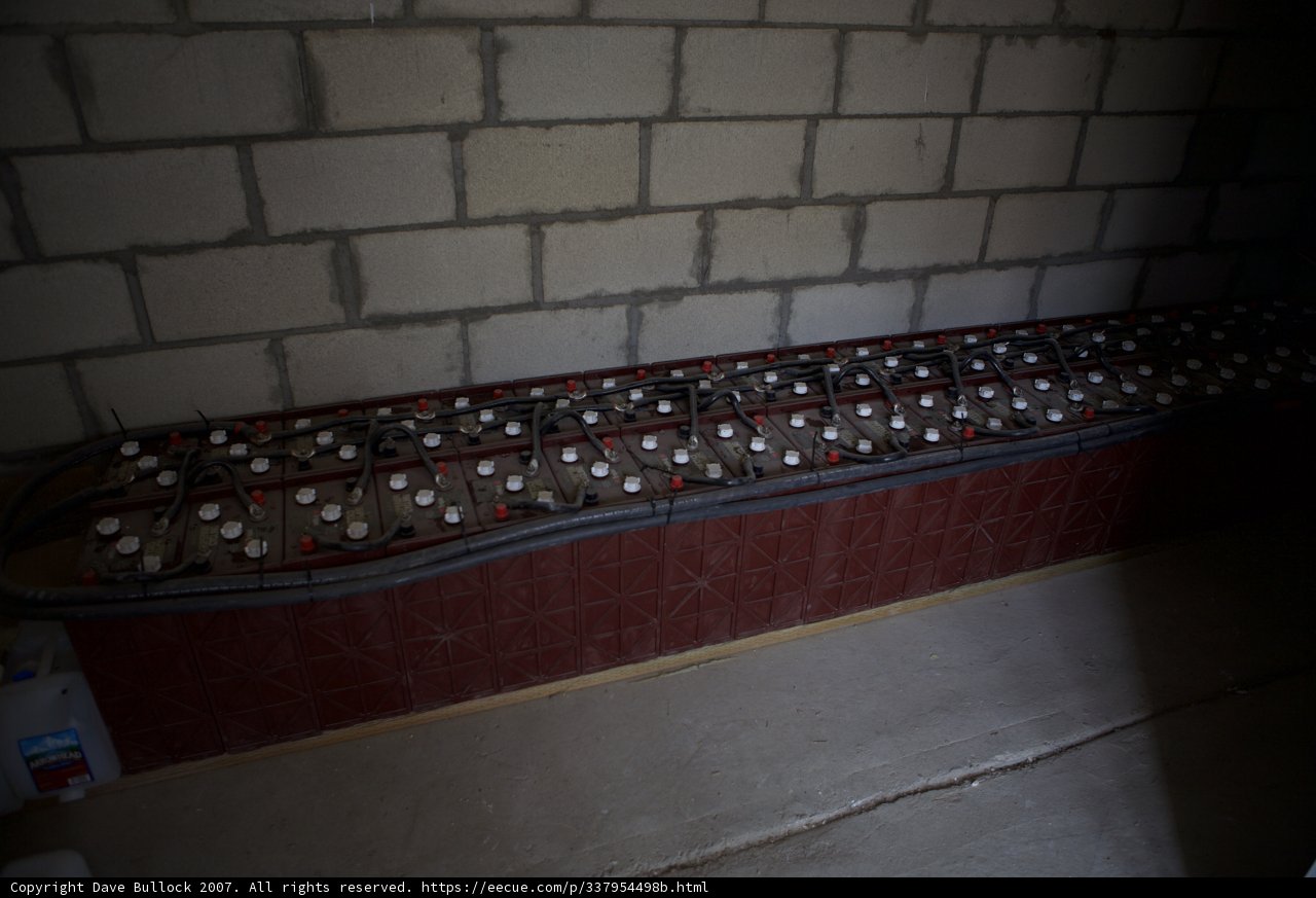 Bottles lined up against a brick wall