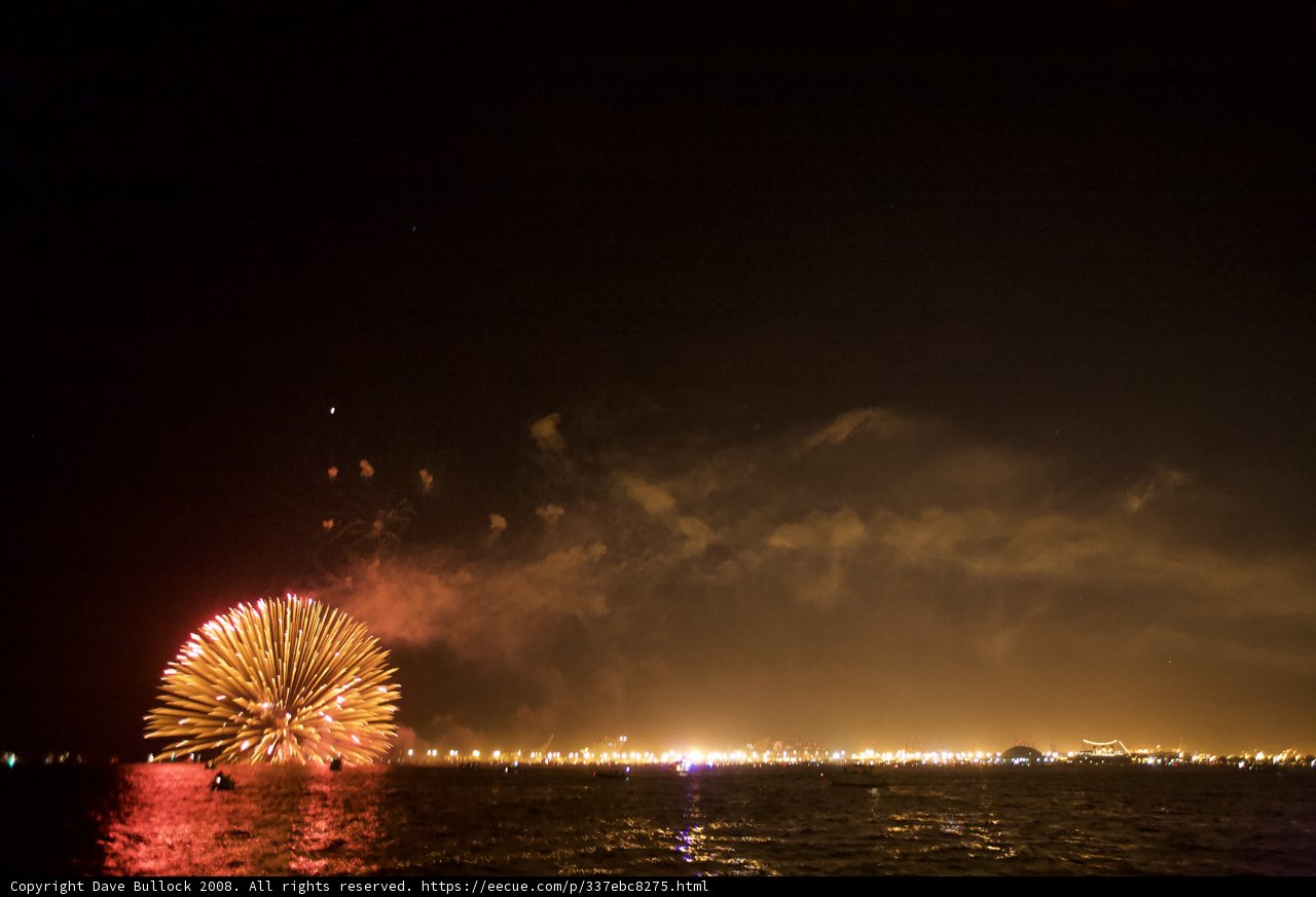 Sparkling Fireworks Over Water at Night