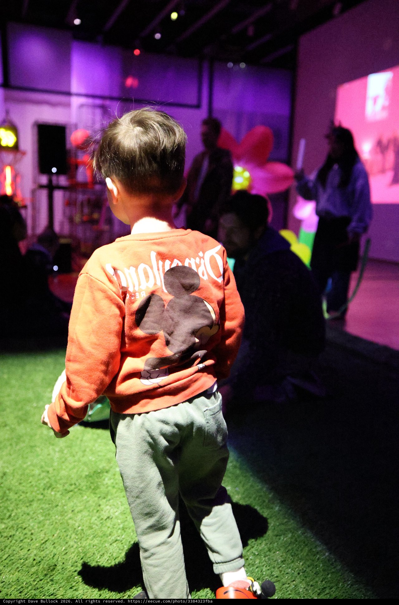 Child Dancing at Purple-Lit Baby Rave Event