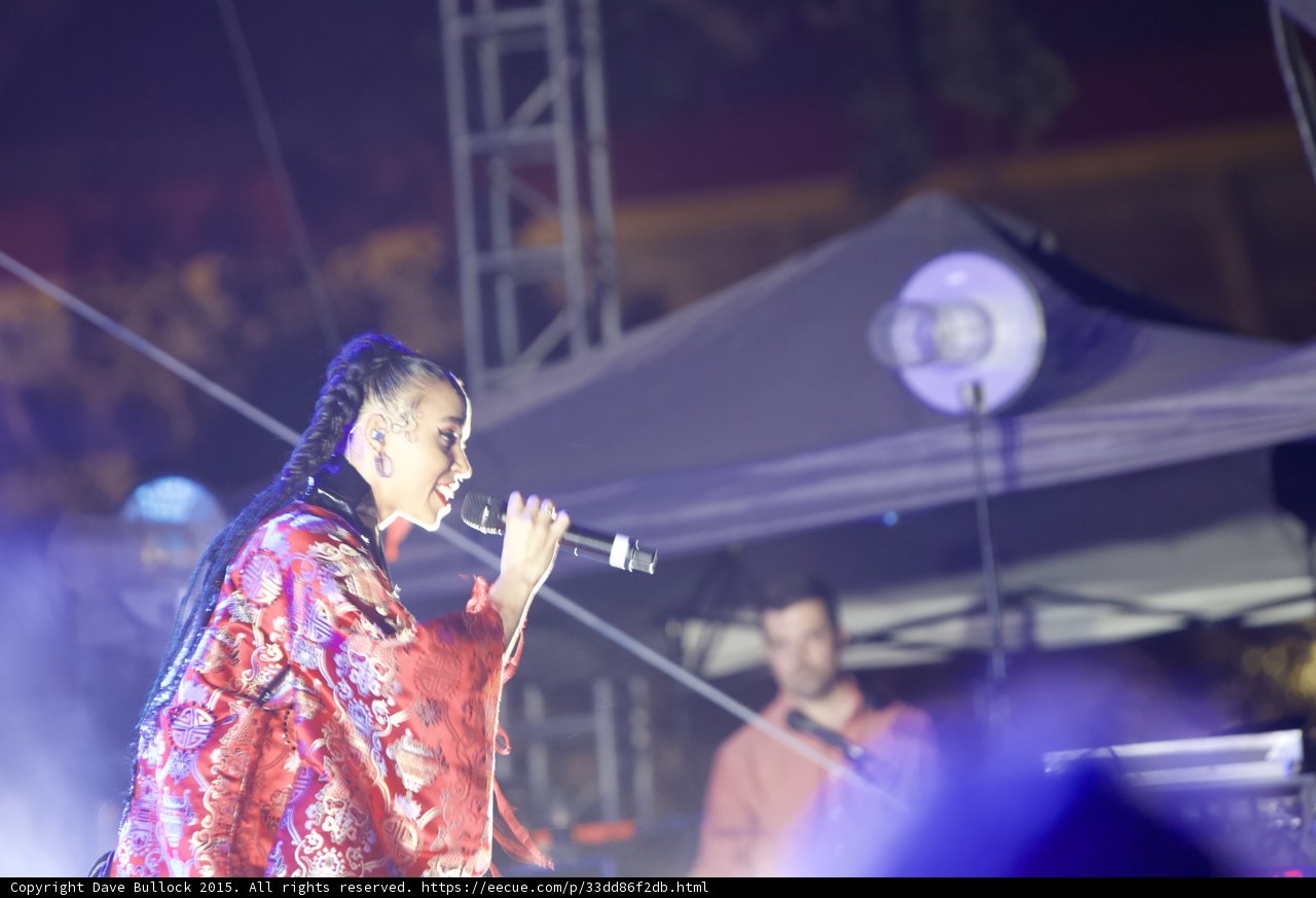 FKA twigs Upper Body Profile Singing Energetically Baby Hairs Swirls Hoop Earrings Red Lipstick Braided Ponytail Kimono Red Brocade Gold Patterns Stage Truss Band Drums Haze