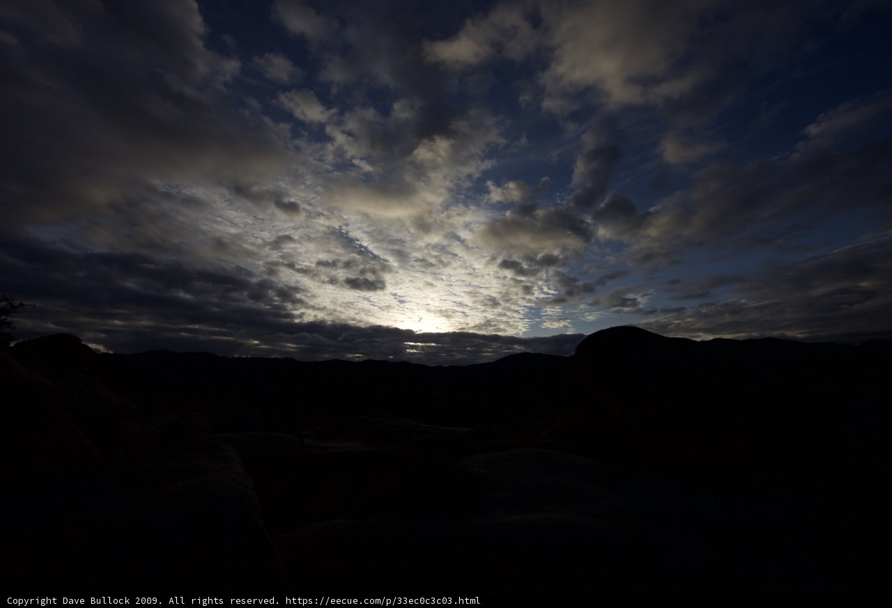 Rocky Silhouette under Blue Sky and Clouds