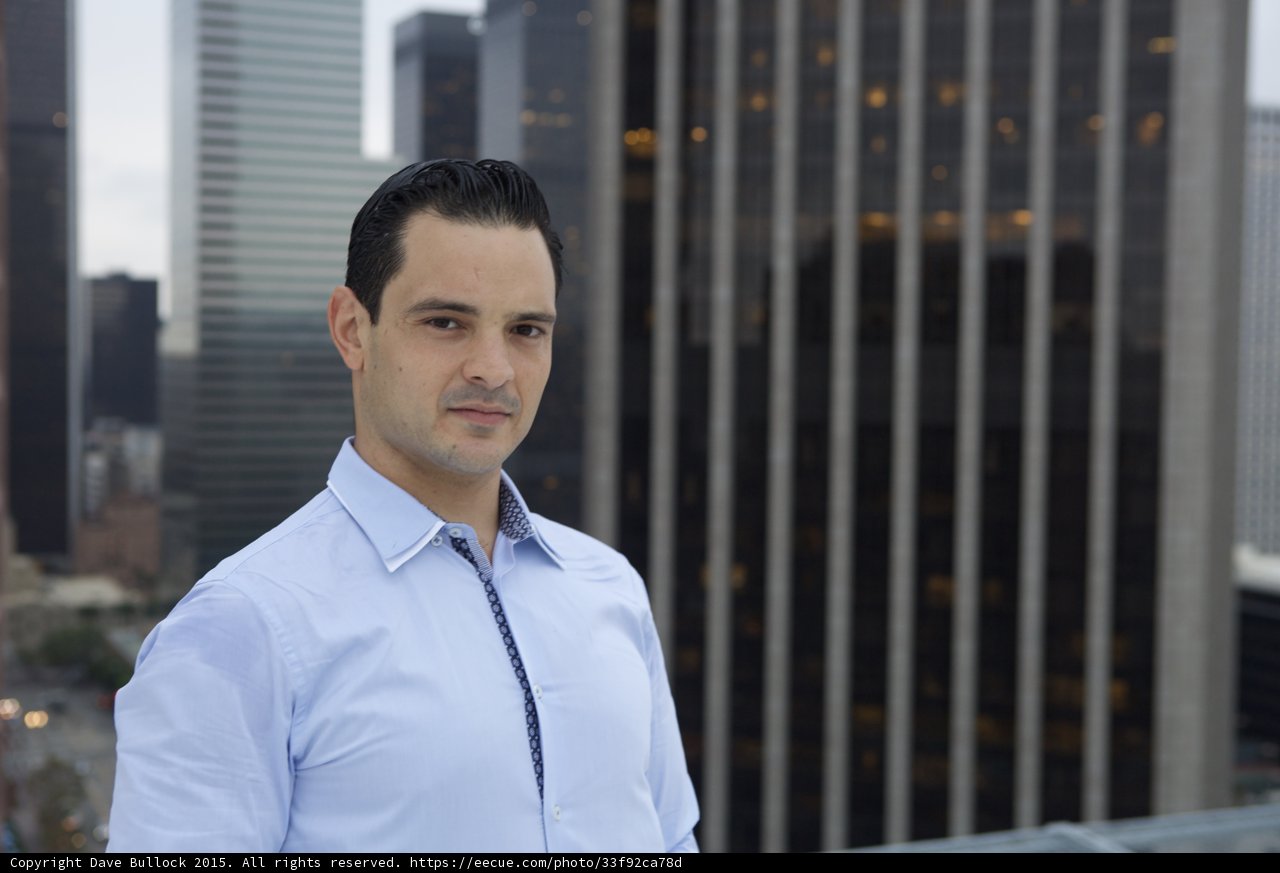 Man in Blue Shirt Contemplating City Skyline