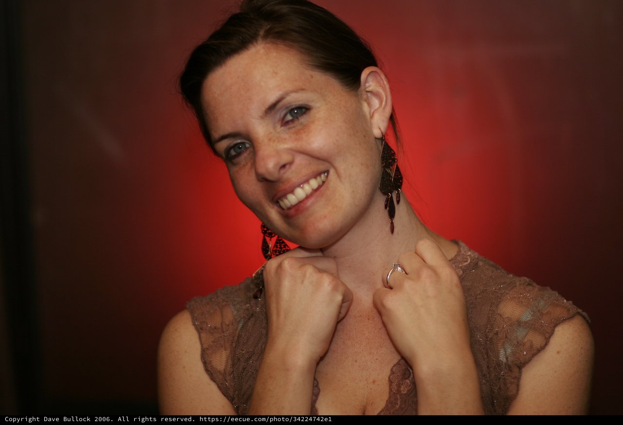 Smiling Woman in Lace Dress Against Red Background