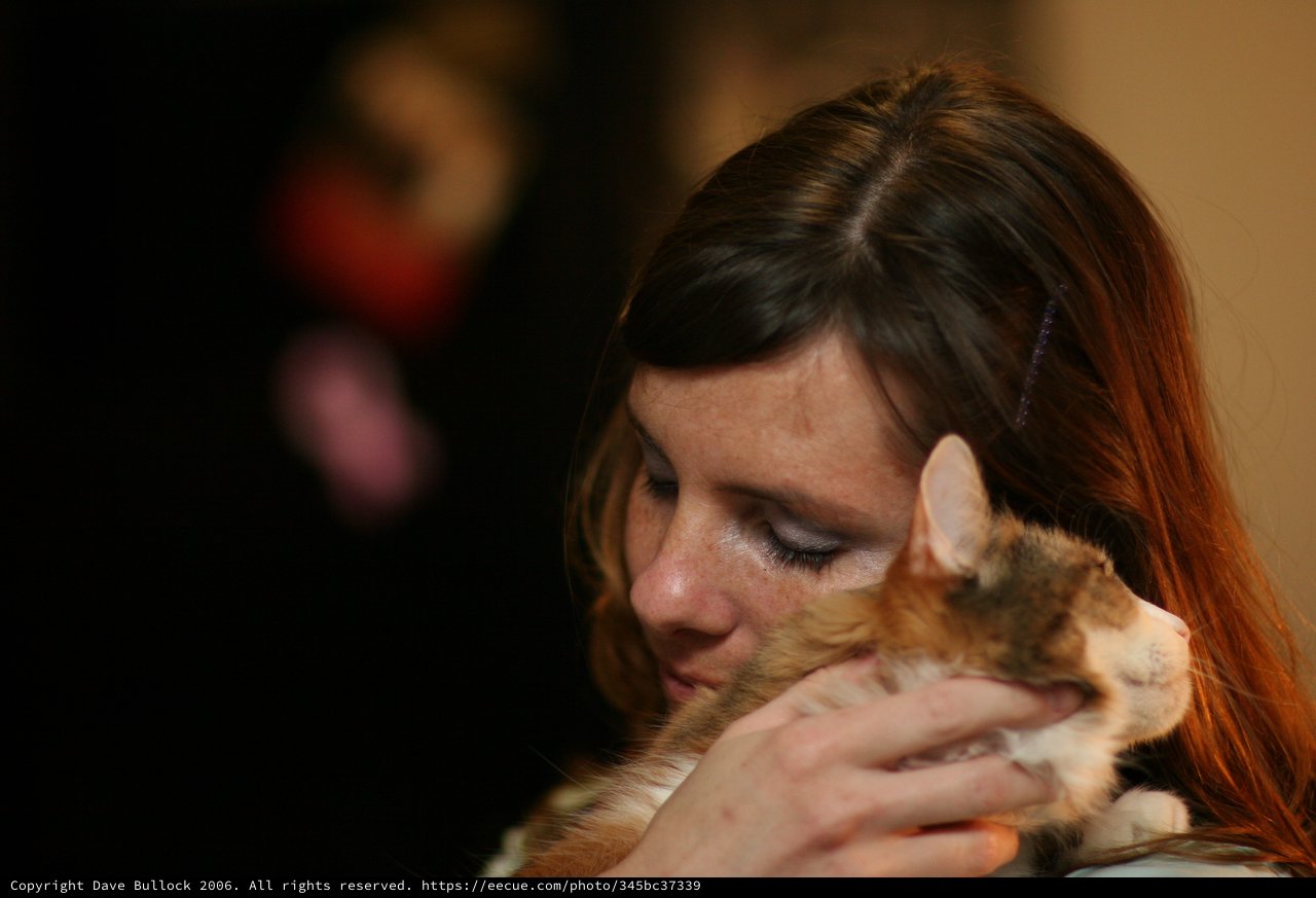 Tender Moment: Woman Embracing Her Calico Cat