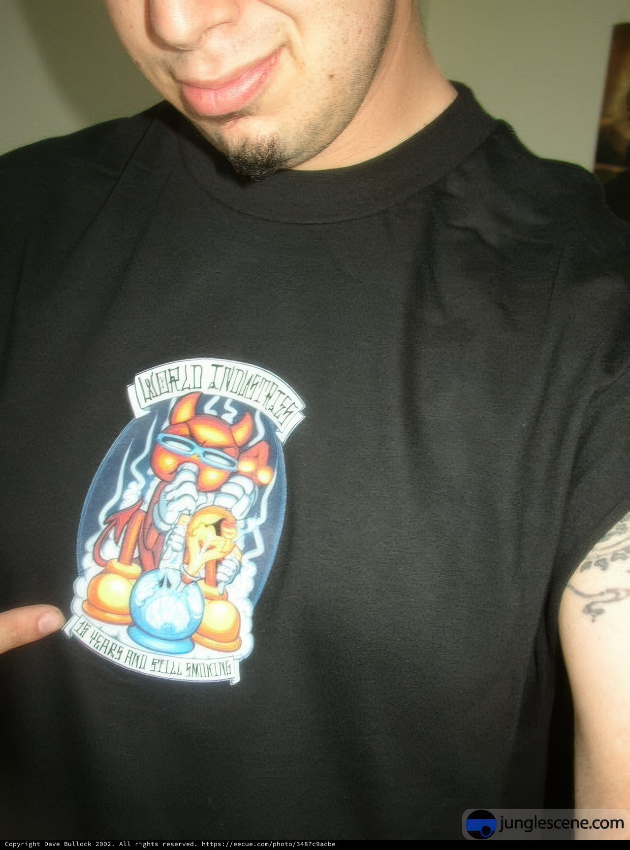 Tattooed man showing off cartoon t-shirt