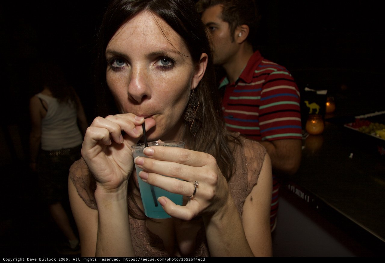 Woman Sipping Blue Cocktail at Nightclub