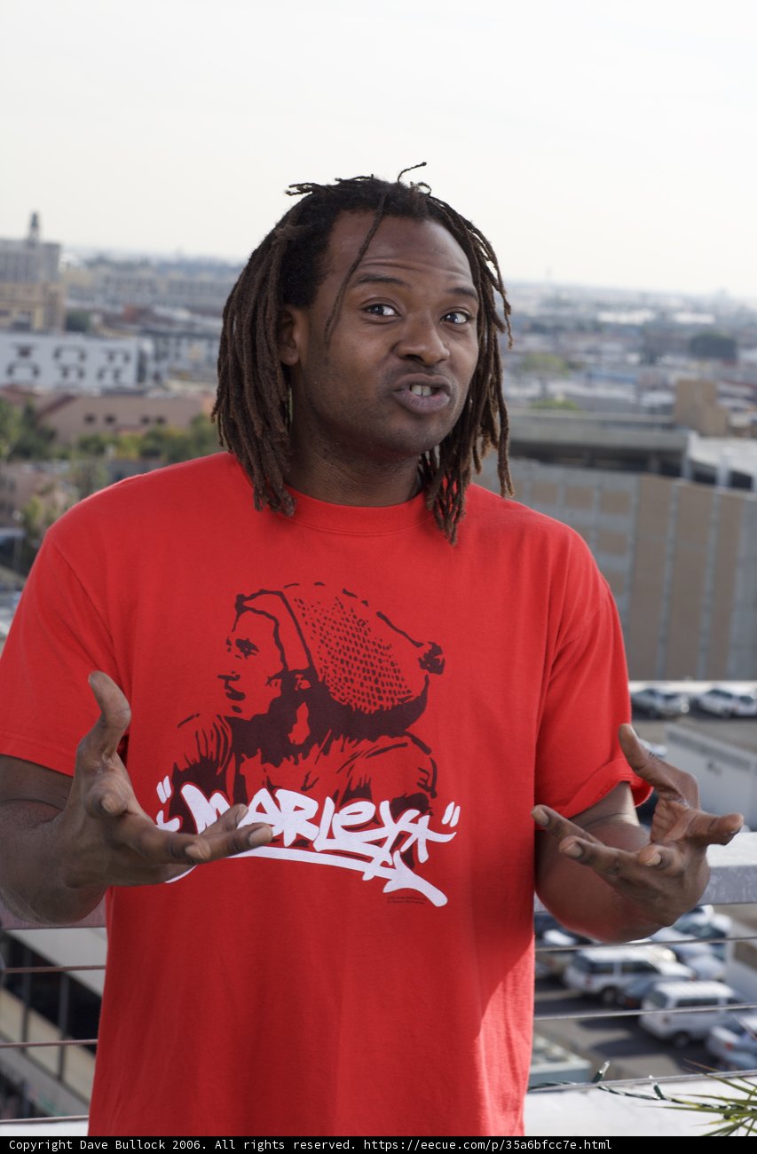 Red-Shirted Man Posing Against Cityscape