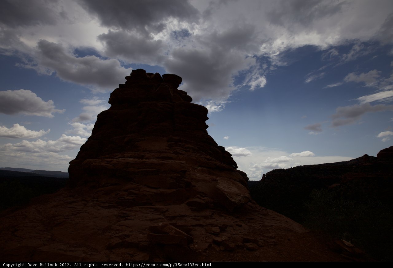 Silhouetted Rock Formation against a Captivating Cloudy Sky