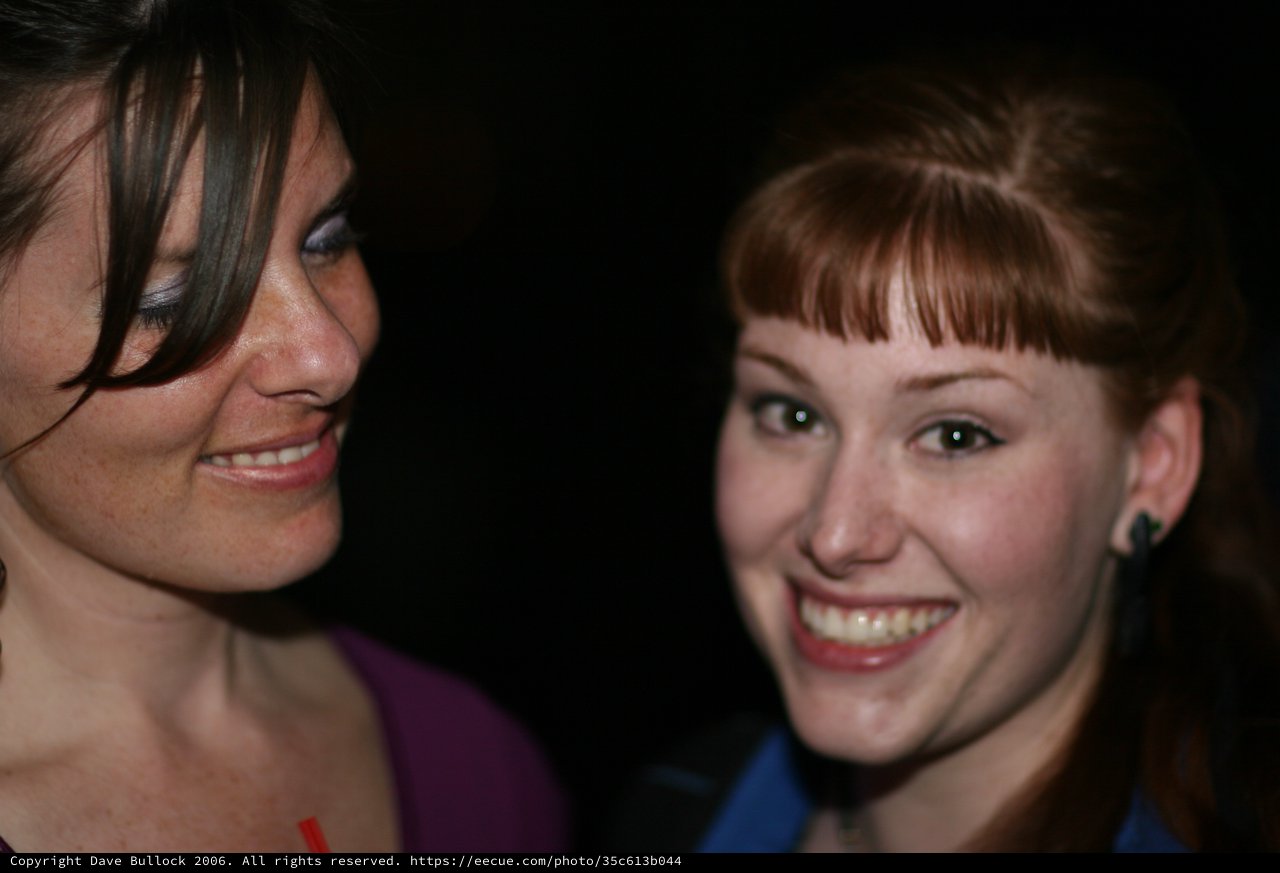 Two Young Women Smiling at a Nighttime Event