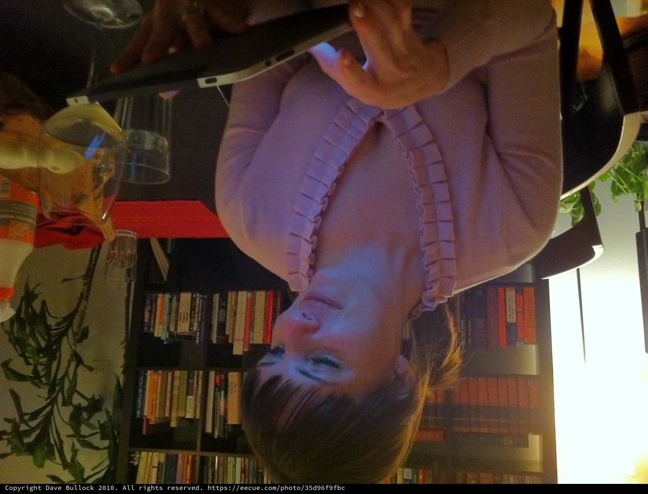 Woman Captivated by Tablet Glow in Dim Library