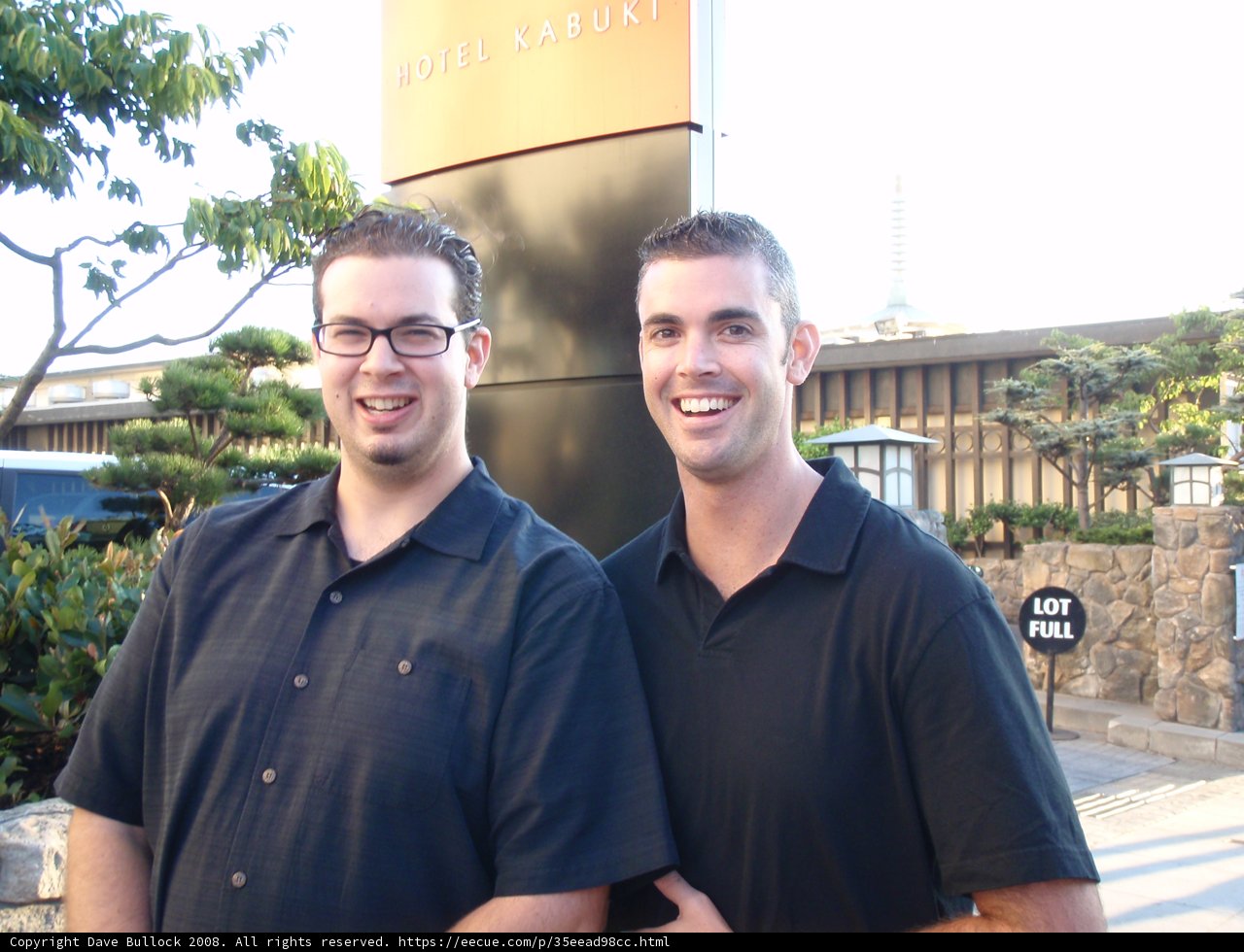 Two Men in Black Shirts Pose for a Portrait