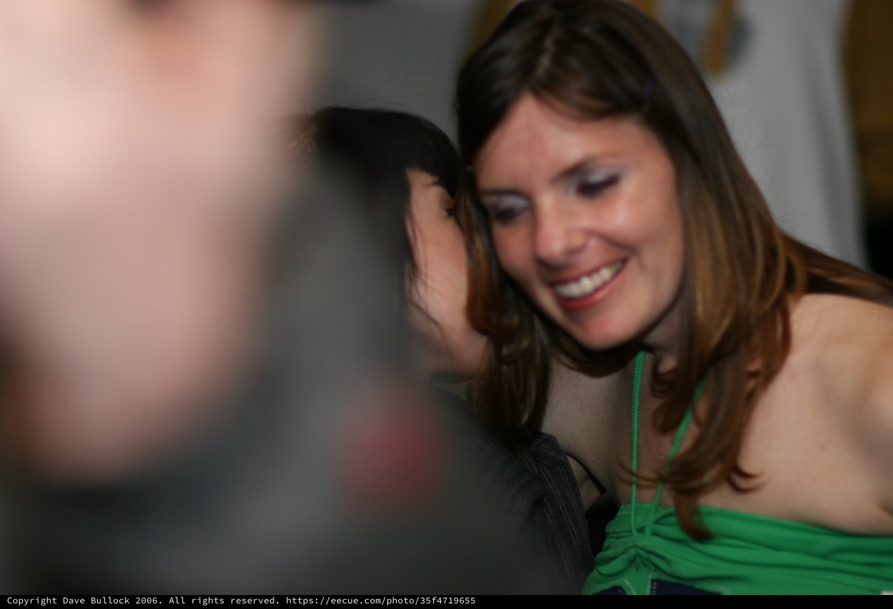 Joyful Whisper Between Two Women at Party