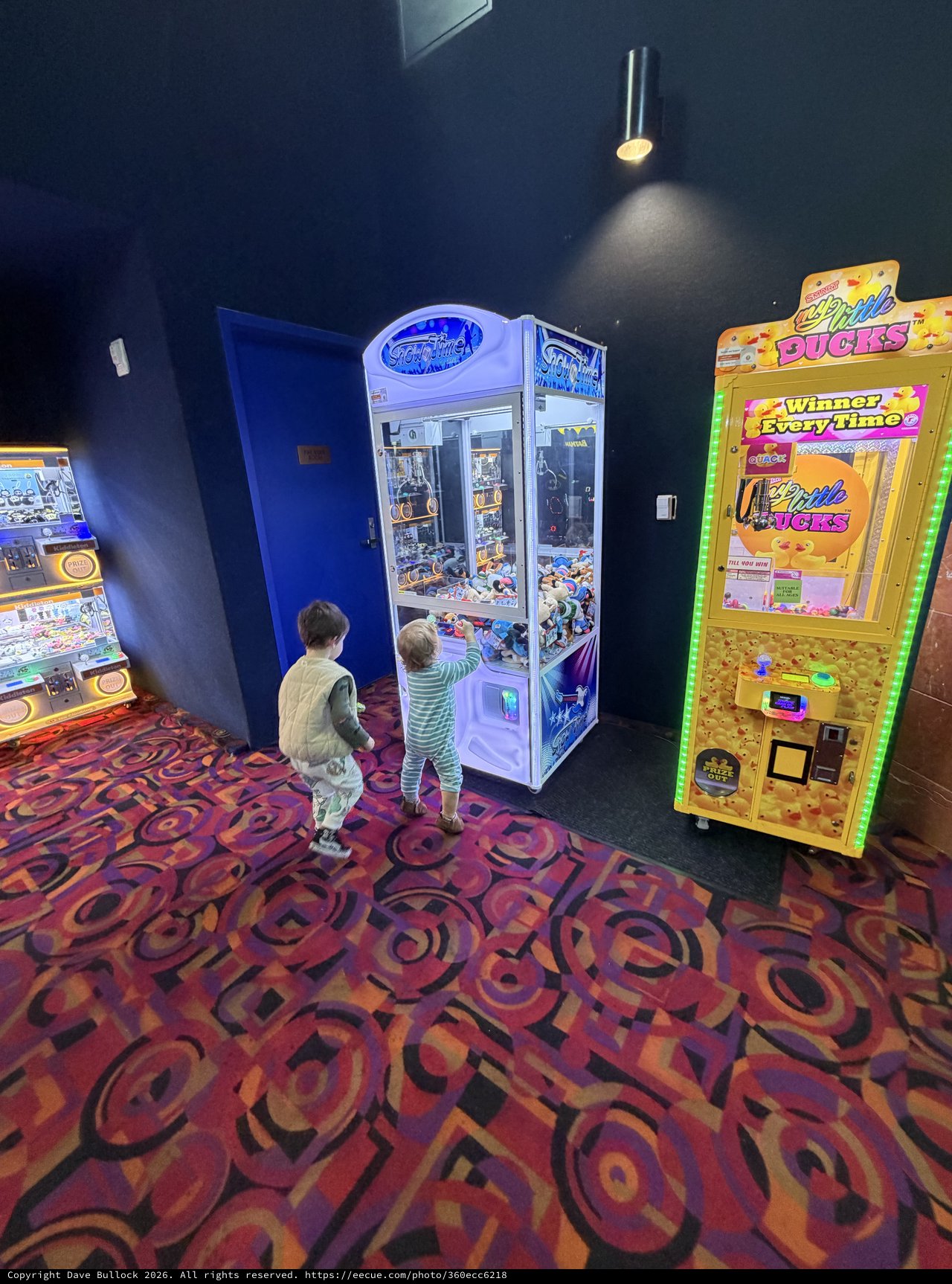 Children Playing Claw Machines at Arcade Entertainment Center